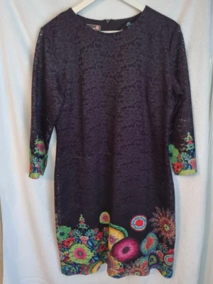 Klänning - Desigual svart klänning i storlek 42 men liten i storleken så mer som en 40. Fint begagnat skick men finns en defekt som är ett vitt sträck på höger framsida, se bild.