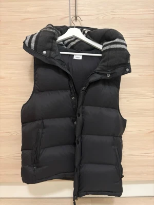 Burberry jacka väst - Säljer en svart pufferjacka från Burberry med avtagbara ärmar så den kan användas som väst. Kommer med tags. Storlek L men passar även M.