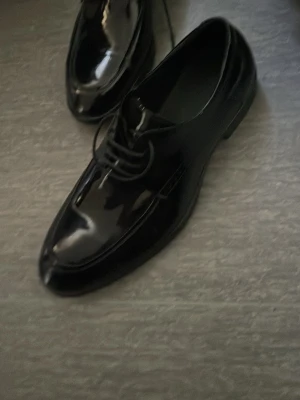 Nike Air Jordan 1 High blå/vit - Säljer ett par Nike Air Jordan 1 High sneakers i blått, vitt och marinblått. Klassisk high-top siluett med ikonisk Swoosh-logga på sidan. Skorna har en vit mellansula och levereras med extra skosnören i rött och blått. Perfekta för dig som gillar streetwear och sneakerskultur.