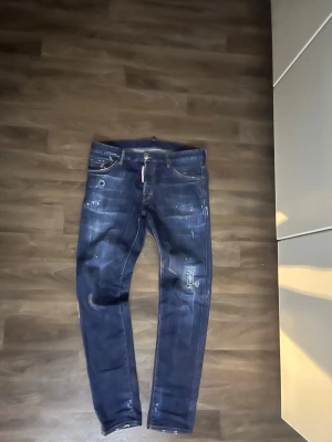 Mörkblå skinny jeans från DSQUARED2 - Ett par sköna ds2 jeans i storlek W32. Riktigt fräscha med gul färgstänk och ds2 patch på baksidan. Skriv via intresse så kan pris diskuteras!