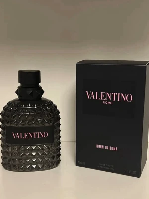Valentino Uomo Born In Roma EdT - Valentino Uomo Born In Roma är en parfym med en lyxig svart flaska dekorerad med nitar och rosa text. Flaskan har en unik, edgy design och kommer i en matchande svart kartong. Perfekt för dig som vill ha en exklusiv och modern doft.