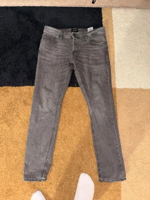 Grå slim fit jeans från H&M - Snygga grå slim fit jeans från Jack&Jones. Storlek 34/32.