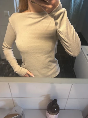 Beige långärmad topp. - Säljer en beige långärmad topp med ribbad struktur ifrån Mango i storlek M. Jätte fin och använd 3 ggr💕