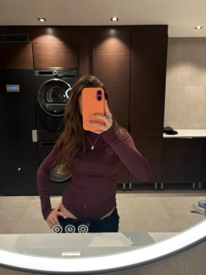 Vinröd body  - Snygg vinröd  långärmad body  med tight passform. Enkel och stilren design utan synliga detaljer, perfekt att matcha med olika outfits. Mjuk och stretchig känsla, passar dig som gillar minimalistisk stil.