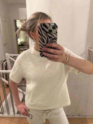 Vit stickad topp med kort ärm - Mysig vit stickad topp med korta ärmar och rund hals. Storlek XS från Gina🥰🥰 