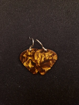 Bruna marmorerade örhängen i plast - Unika örhängen med triangulär form i brunmarmorerad plast. De har en skimrande yta som ger ett coolt djup och hängs på enkla metallkrokar. Perfekta för dig som gillar retrovibbar och vill sticka ut med accessoarer som känns både trendiga och personliga. Örhängena är gjorda av plektrum. 