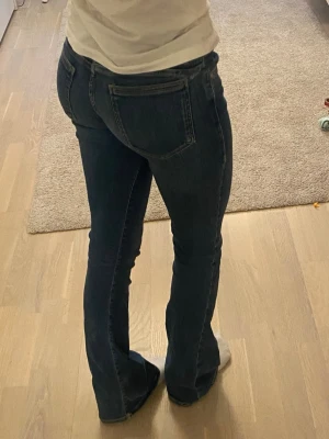 Mörkblå bootcut jeans med stretch - Snygga mörkblå bootcut jeans med normal passform och stretchigt material. Klassisk femficksmodell och hög midja som framhäver figuren. Perfekta till sneakers eller boots för en avslappnad look.