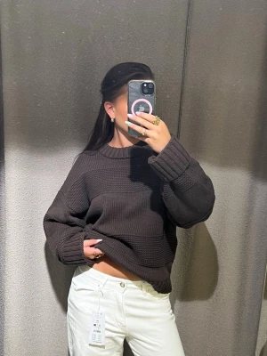 Oversize brun kablestickad stickad tröja - En riktigt snygg och oversize brun stickad tröja med breda ribbade muddar på ärmar och nederkant. Förekommer fläckar på rk av baksida ärm som man kan se på sista bilden