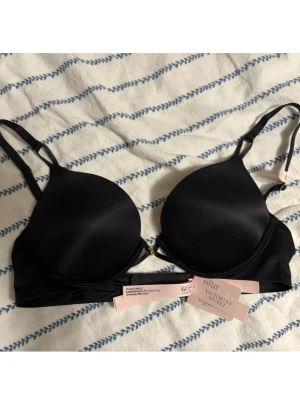 Victoria's Secret Bombshell Add-2-cups Push-up BH - Jättefin bh från Victoria's Secret. Söt guldig VS logga framtill. Helt ny med lappar kvar, endast provad. 34A, passar mig som normalt har 75A. 