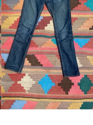 Acne Selvedge jeans - Säljer ett par feta raw selvedge acne jeans som använts i några år vilket skappat sjuka fades. Passformen är mott det slimmade hållet men ändå lite rakare i benen än nudie Jean klassiskt modell. Storleken är 30W 32L men passar snarare 28-29 i W