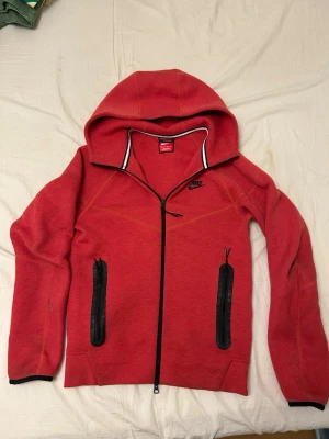 Nike tech fleece röd - Jag köpte detta Nike tech fleece för 1400kr och den är bra kondition lite smutsigt men allt annat är bra. Jag säljer den här Nike tech fleece för att den passar inte mig längre.