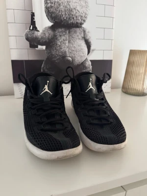 Svarta Air Jordan sneakers mesh - Säljer ett par svarta Air Jordan sneakers med vit sula och klassisk Jumpman-logga på sidan och plösen. Skorna har en luftig mesh-överdel och svarta skosnören. Perfekta för dig som gillar sportig och clean stil.
