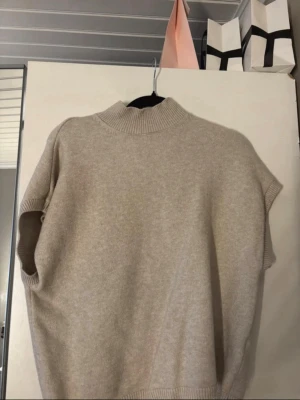 Beige ärmlös stickad tröja Kappahl - Säljer en beige ärmlös stickad tröja från Kappahl. Tröjan har hög ribbad krage och ribbade detaljer vid ärmöppningar och nederkant. Priset går att diskutera!