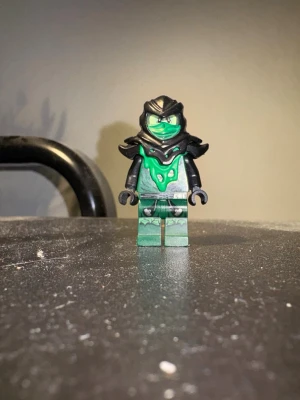 Possessed Lloyd  - Säljer en LEGO-minifigur med ninja-tema. Figuren har grön kropp med svarta detaljer, svart huva och mask samt tryck på bröstet och benen. Perfekt till samlingen eller för att bygga egna äventyr.