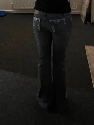 Y2k vintage jeans - Säljer ett par blå bootcut flared jeans med snyggt tryck på bakfickorna. Jeansen har låg midja och är perfekta för dig som gillar retrostil/y2k. Rätt så lågmidjade. Använt fåtal gånger🩶