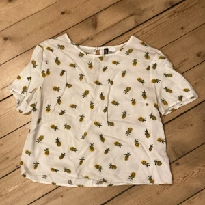 Sommarblus med ananas - Gullig blus med ananasmotiv. Storlek 40 men passar nog allra best mindra storlekar. 