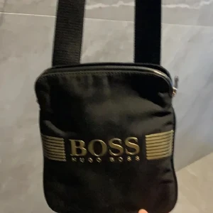 Hugo boss axelarmsväska  - Säljer denna hugo boss väskan pgd av att jag tröttnat på den skick:6/10 då dragkedjan kan f*cka ibland samt hugo boss trycket är lite slitet 