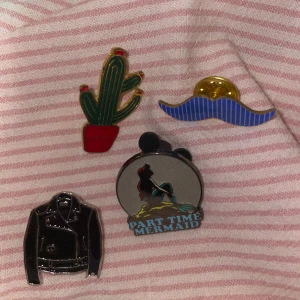 Pins - 4 olika pins man kan sätta på väskor eller kläder. En kaktus pin, en läderjacka pin, en mustasch pin, en Disney lilla sjöjungfru pin. Pris kan diskuteras, kontakta mig gärna om ni har frågor ❤️❤️