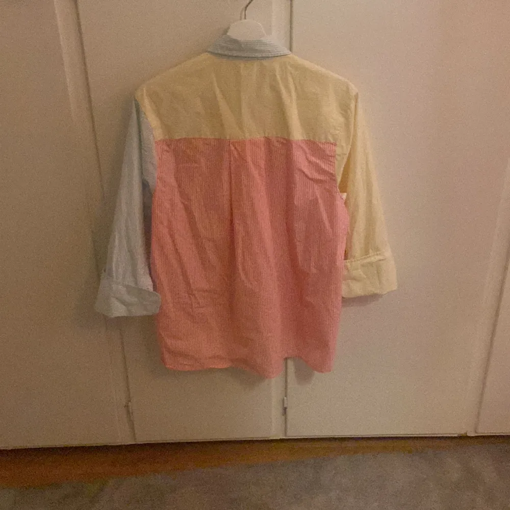 En oversized skjorta i storlek xs från Gina tricot. Den är ljus gul, ljus blå och rosa med vita ränder. Väldigt fint skick. . Skjortor.