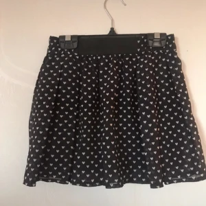 Gullig kjol - Fin svart kjol med en inre tyg och ett yttre (se sista bilden). Har resår i midjan. Är i väldigt bra skick. Storleken 122/128.