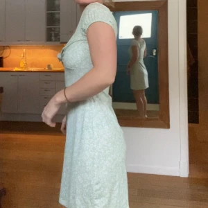 Klänning  - Söt sommarklänning i mjukt materiell.  Vita små blommor i mönstret.  Går att knyta framtill efter egen önskan.  Fint skick.