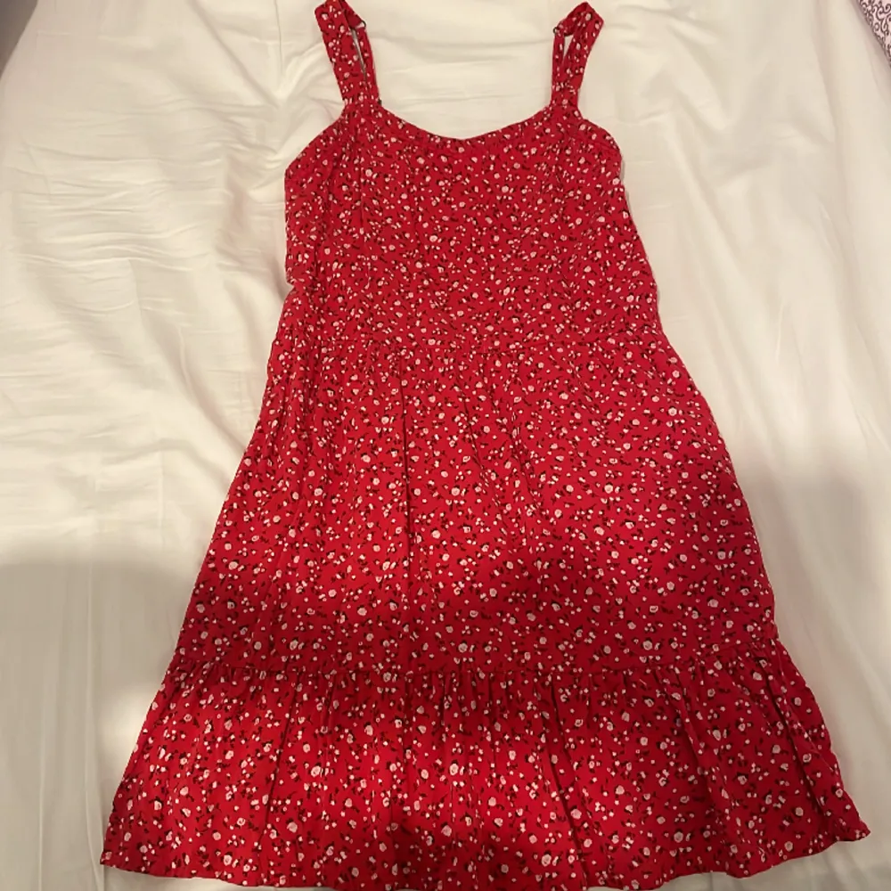 Jättefin röd klänning med blommönster från abercrombie. Den har storlek 13-14 men skulle säga att den är XS-S. Den är väldigt stretchig och har justerbara band. Säljs då den inte kommer till användning längre💗. Klänningar.