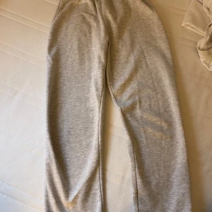 Grå mjukisbyxor - Ett par bekväma grå mjukisbyxor med elastisk midja. Perfekta för avslappnade dagar hemma eller lätt träning.