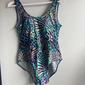 Retro baddräkt i regnbågsfärgat leopardmönster! - Supersnygg retro baddräkt i regnbågsfärgat leopardmönster! Köpt vintage, troligen från 80-talet💜 Djup ringning i ryggen samt inbyggda kupor! Snygg att använda som body till byxor eller kjol!🧚🏼‍♀️ Fint skick <3