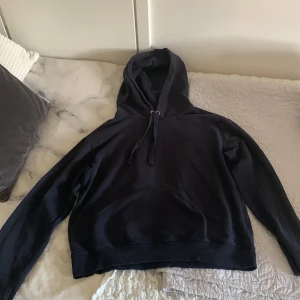 Svart hoodie från H&M - En enkel och bekväm marinblå hoodie från H&M Basics. Hoodien har en justerbar huva med dragsko och långa ärmar. Perfekt för vardagsbruk.