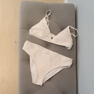 Vit strukturbikini strlk 160 - Vitbeige lätt vadderad bikini. Fint skick, knappt använd. Strlk 160