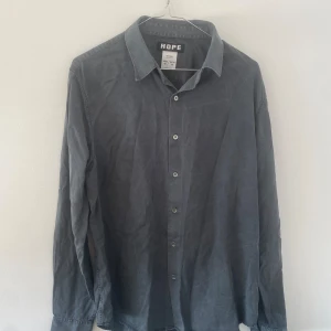 Hope air clean shirt - Säljer en riktigt fin svartgrå skjorta från Hope i strl 46/S! Något avslappnad fit, en perfekt basvara för garderoben. Använd ett fåtal gånger, som ny.
