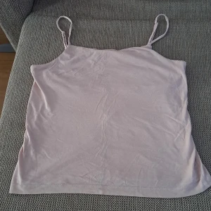 Ljusrosa linnetopp från 157 - En enkel och stilren ljusrosa linnetopp från 157. Toppen har smala axelband och är tillverkad i ett mjukt och bekvämt material. oanvänd. 