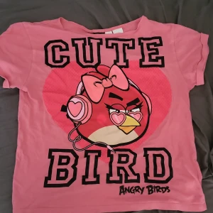 En mörkrosa Angry birds T-shirt i storlek M - en mörkrosa angry birds T-shirt  i bra skick inga hål eller nått  använd 1 gång och i bra skick. 😀