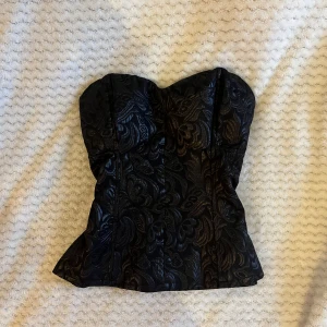 svart korsett-topp  - Svarr mönstrad korsett-topp i strl 38. Oanvänd med lapp kvar! 