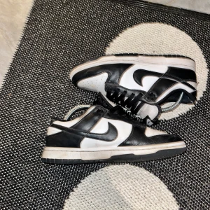 Nike dunks  - Hej! Jag säljer mina nike dunks i färgen panda. De är använda men väldigt fina. På framsidan då är de lite smutsiga men det går säkert att tvätta bort. De är även lite creesade men det går enkelt att fixa med strykjärn.  Nypris 1200. Kan gå ner i pri
