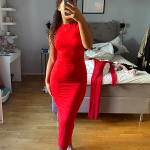 Klänning - En super fin röd klänning som passar bra till både fin middag och vardag, den har scrunchat tyg i midjan som får din figur att se fin ut! Nytt skick