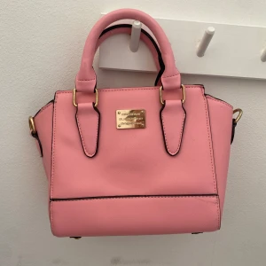 Gullig rosa väska  - Super gullig liten rosa väska med tillkommande långa Väskremmar, säljer då den inte kommer till användning. Aldrig använt så super bra skick. Skriv för mått. 