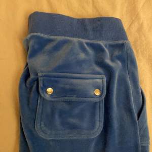 Säljer dessa blåa juicy byxor då de är lite för stora. De är rätt använda så de är lite bleka i färgen men är ändå i bra skick.