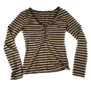 Randig tröja  - En randig tröja med knappar, köpt secondhand. Den är s/xs men med stretchigt material.