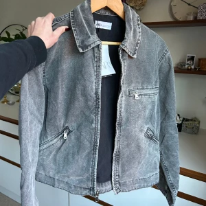 Zara jacka - Populär grå-tvättad jeans jacka från zara. Helt ny med prislappen kvar. Slutsåld på zaras hemsida och nypris ligger på 559kr! Supercool modell och passar både större och mindre storlek beroende på hur man vill att den ska sitta. Perfekt vårjacka!