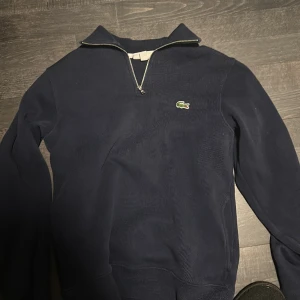 Lacoste 1/4 zip - Mörkblå Lacoste zip.