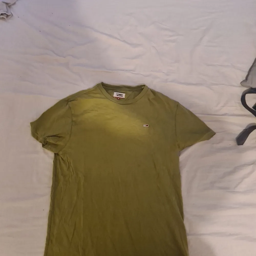 Säljer en Knappt använd Tommy hilfiger tshirt i storlek XL, den är felfri och i nyskick! Färgen är knepig att beskriva men skogsgrön/olivfärgad, som mossa typ.. . T-shirts.