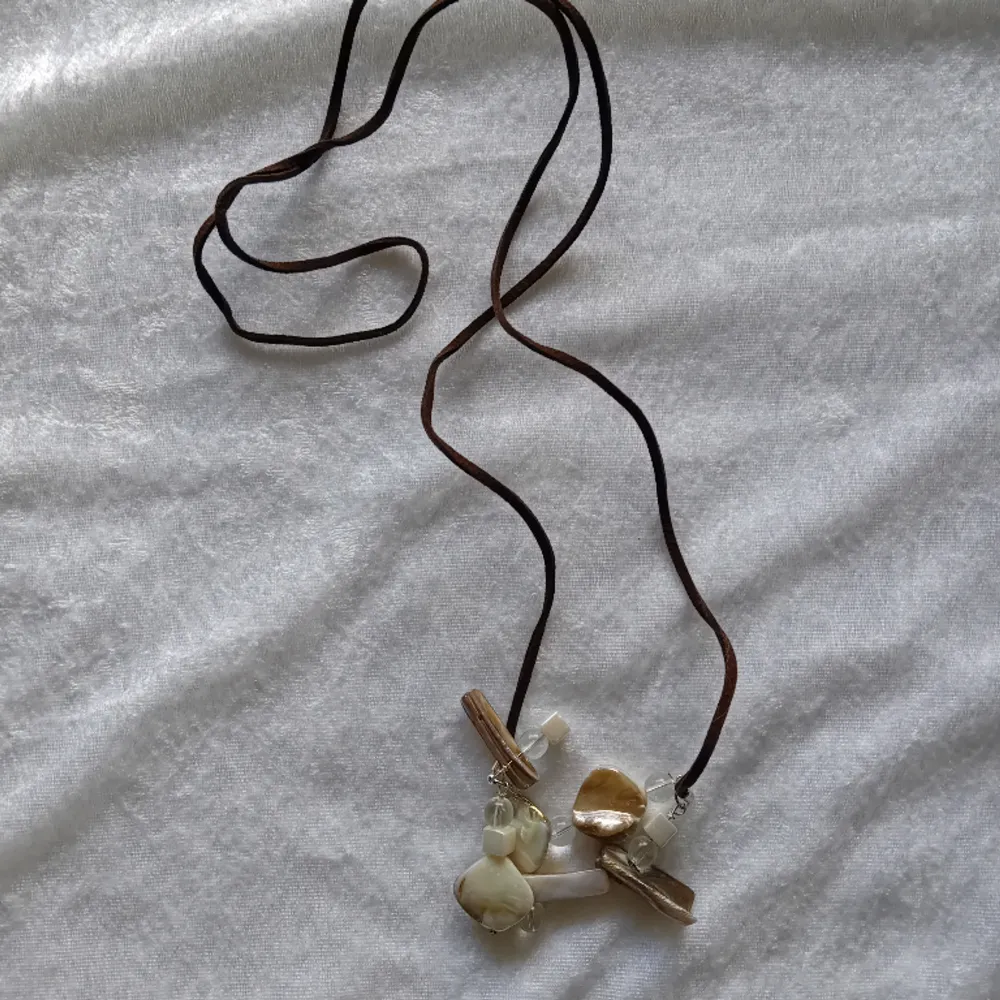 Handgjort halsband med brunt mockaband på 1 meter och pärlemo färgade pärlor . Accessoarer.