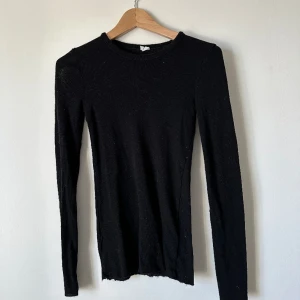 Svart långärmad tröja - Svart långärmad topp i merinoull från arket. Toppen har smal passform och råa kanter i ärmsluten och i nederkant. Snyggt basicplagg som funkar till många sammanhang och dessutom lite värmande. Sparsamt använd och i fin kvalitet 💕