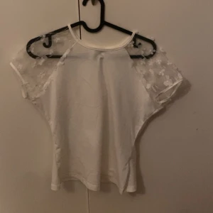 Vit tröja med blommiga armar  - Storlek s Har aldrig blivigt buren 