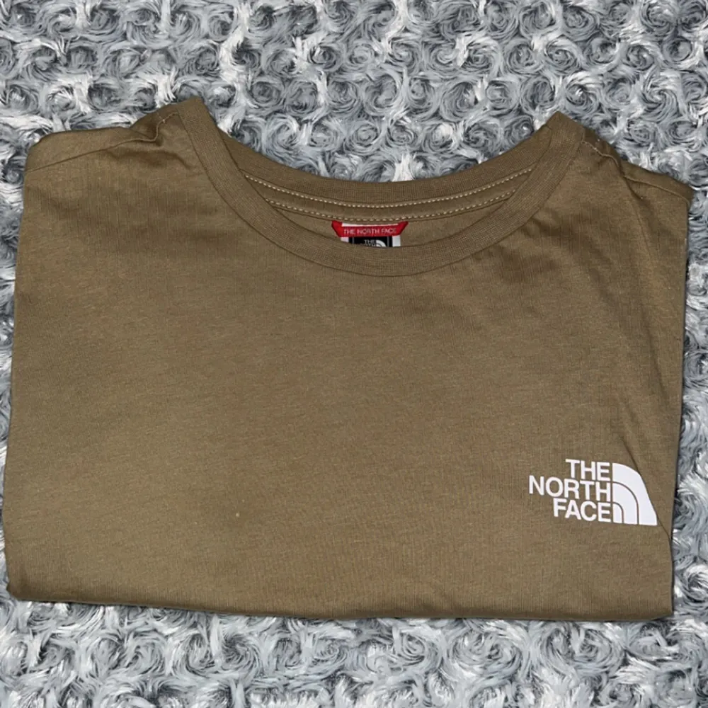 The north face tshirt I beige färg med logga på vänstra bröst och logga på högra rygg sidan, storlek M använt ett par gånger men är i bra skick . T-shirts.