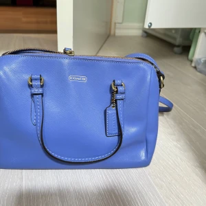Coach väska blå liten crossbody  - Min gammal coach väska, förvarades nästan 10 åringar, men läder är fortfarande jätte fint.  Bredden är små och medelstora.  Använts inte så mycket, så vill jag säljas.  Stort utrymme och praktiskt. Axelremsskada, men inte uppenbar.