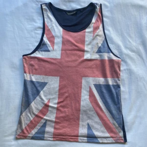 Storbritannien flagga tanktop XL - Tanktop oversized med Storbritanniens flagga, köpt på en resa. Färgen på flaggan är med mening då den ska se ut att vara lite ”tattered” eller välanvänd, men tröjan är i bra skick och har inga problem. Kom gärna med prisförslag!!!