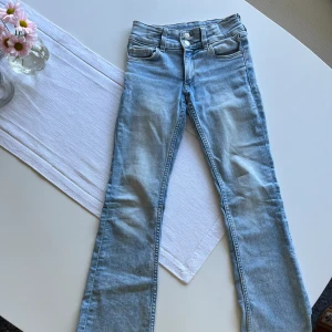 Ljusblå low waist bootcut jeans - Byxorna har bara använts några gånger och är i mycket bra skick. Inga bakfickor. Och har justerbar midja