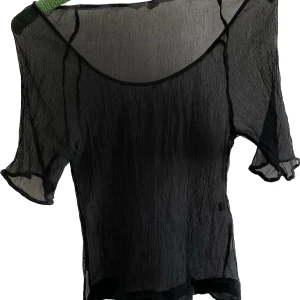 Top - Tunn genomskinlig, typ off shoulder med knytdetalj vid höften. Stretchig pga att tyget är veckat. 